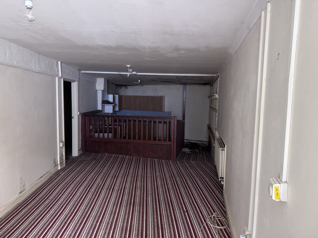 Lot: 9 - TOWN CENTRE BUILDING ARRANGED AS THIRTEEN FLATS IN NEED OF SIGNIFICANT IMPROVEMENT - One of the flats living room